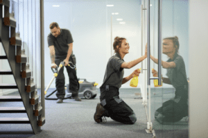 commercial cleaner wiping an office window